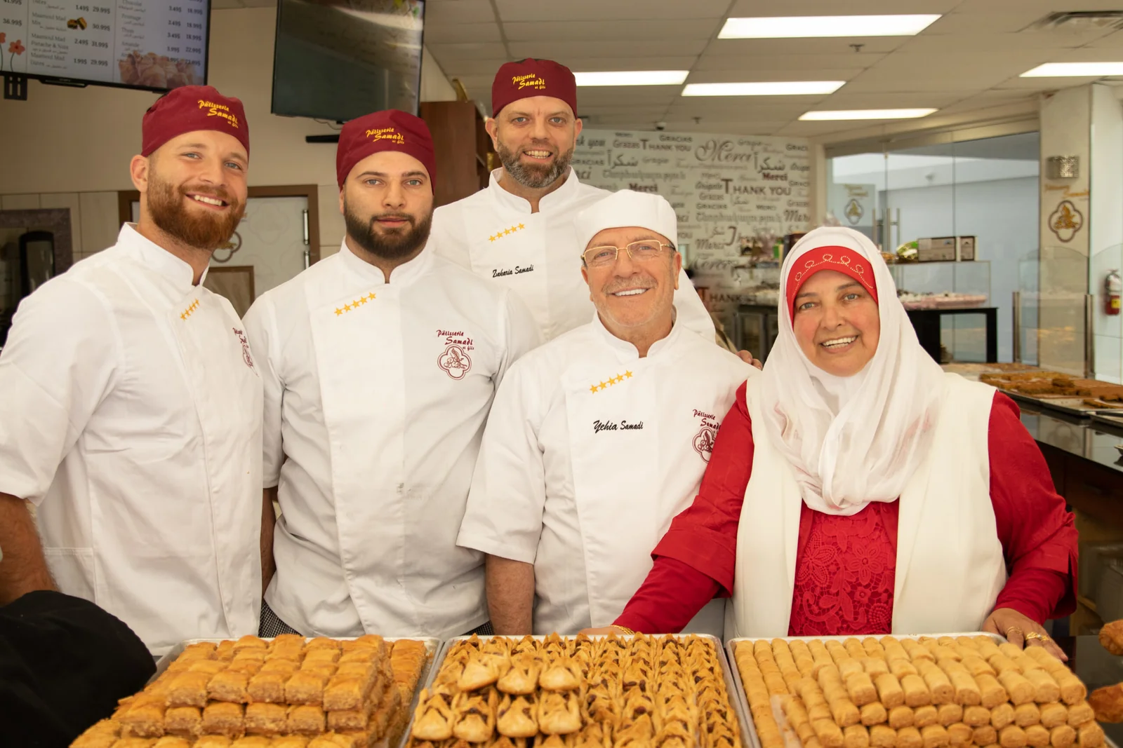 The Samadi family of pastry chefs behind trays of fresh baklava in their Montreal shop